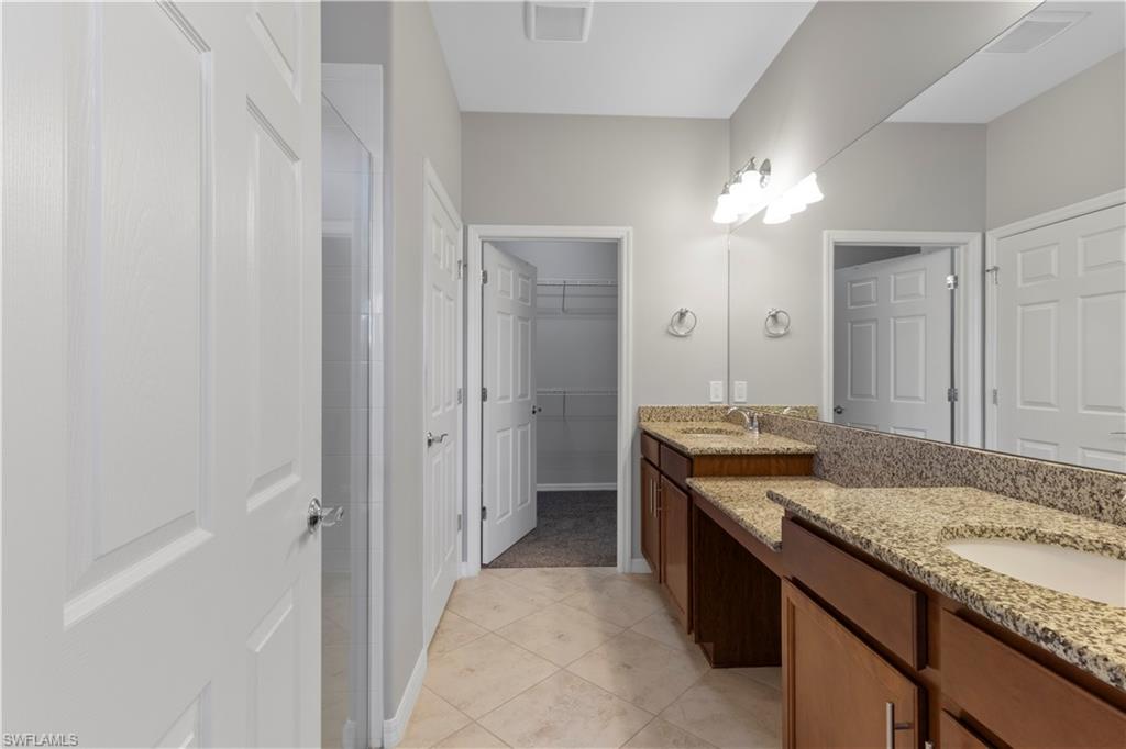 6068 Triumph Lane Ave Maria, FL 34142 - Photo 18 of 27 a bathroom with a granite countertop sink and a mirror