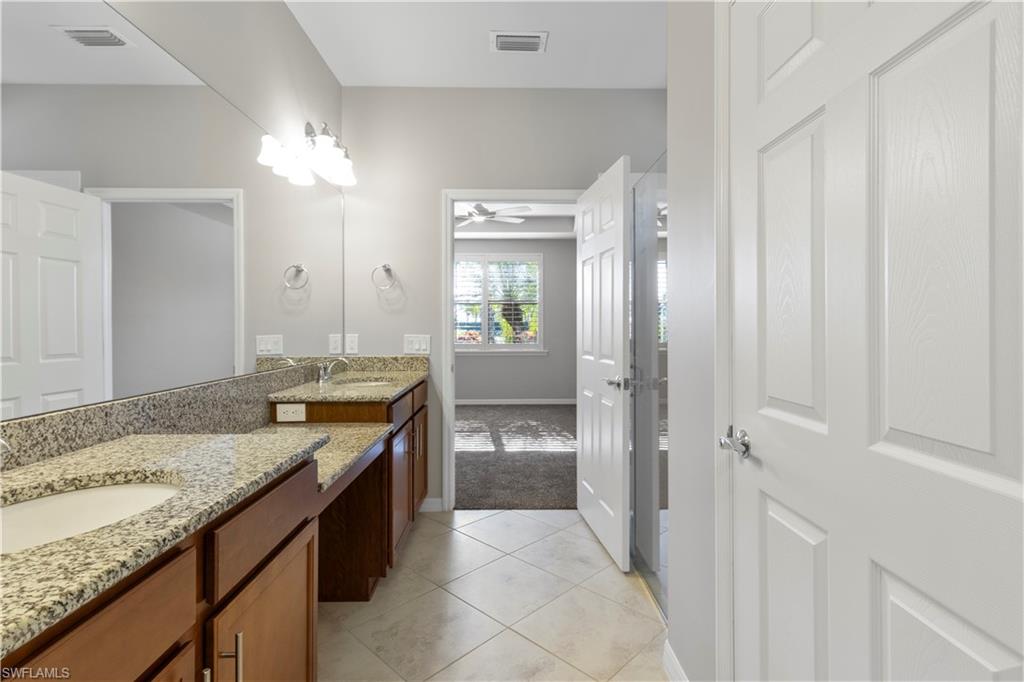 6068 Triumph Lane Ave Maria, FL 34142 - Photo 21 of 27 a bathroom with a granite countertop sink a toilet and shower