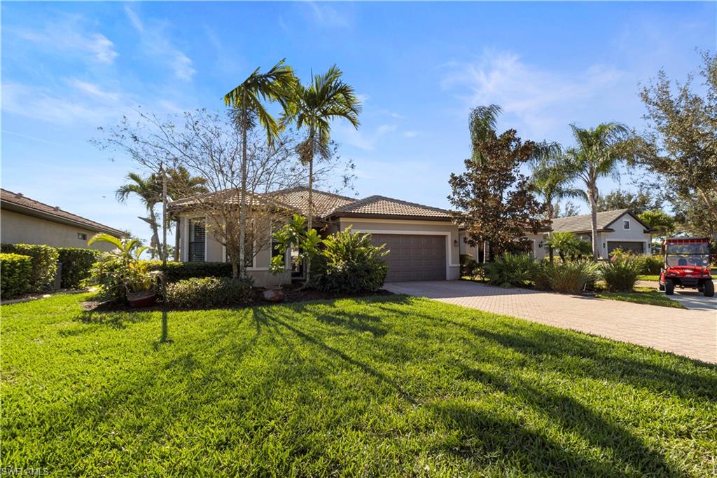6068 Triumph Lane Ave Maria, FL 34142 - Photo 3 of 27 a front view of a house with a garden and a yard