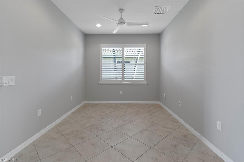 6068 Triumph Lane Ave Maria, FL 34142 - Photo 9 of 27 an empty room with chandelier fan and windows