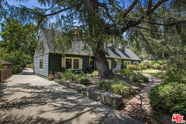 a front view of a house with a yard and shrubs