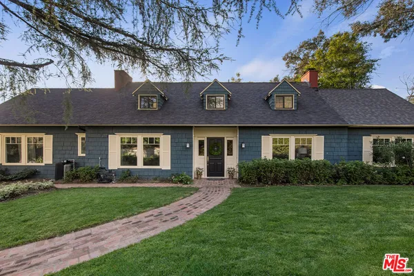 a front view of a house with a yard and green space