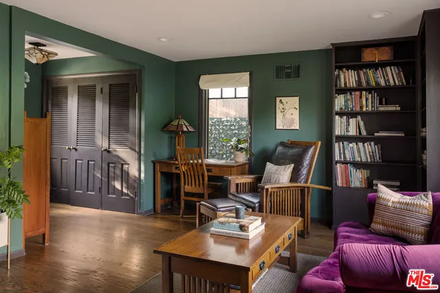 a living room with furniture and a book shelf