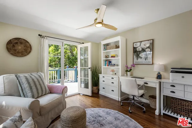 a view of a livingroom with workspace and a window