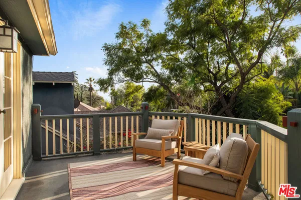 a balcony with wooden floor and outdoor seating