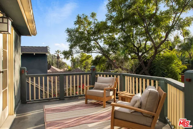a balcony with wooden floor and outdoor seating