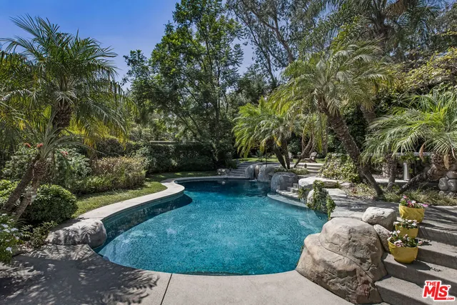a view of backyard with swimming pool and sitting area