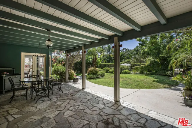 a view of a patio with table and chairs and floor to ceiling window