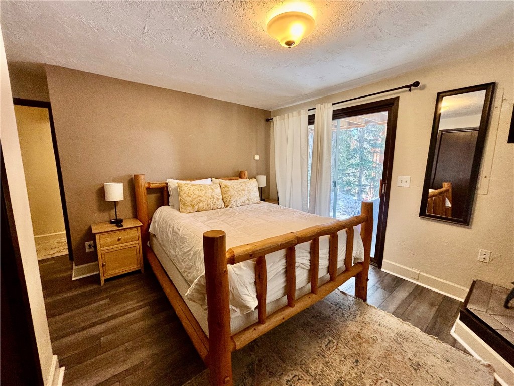 1310 Baldy Road, Unit D Breckenridge, CO 80424 - Photo 23 of 28 a bedroom with a bed and wooden floor