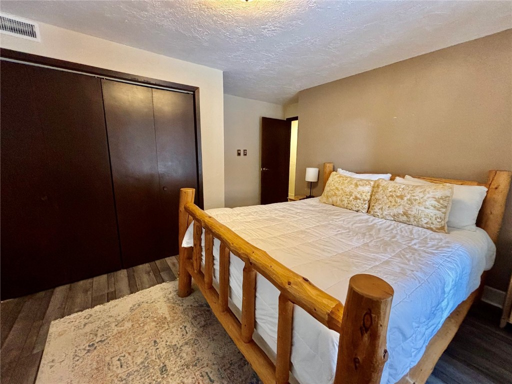 1310 Baldy Road, Unit D Breckenridge, CO 80424 - Photo 24 of 28 a bedroom with a bed and wooden floor