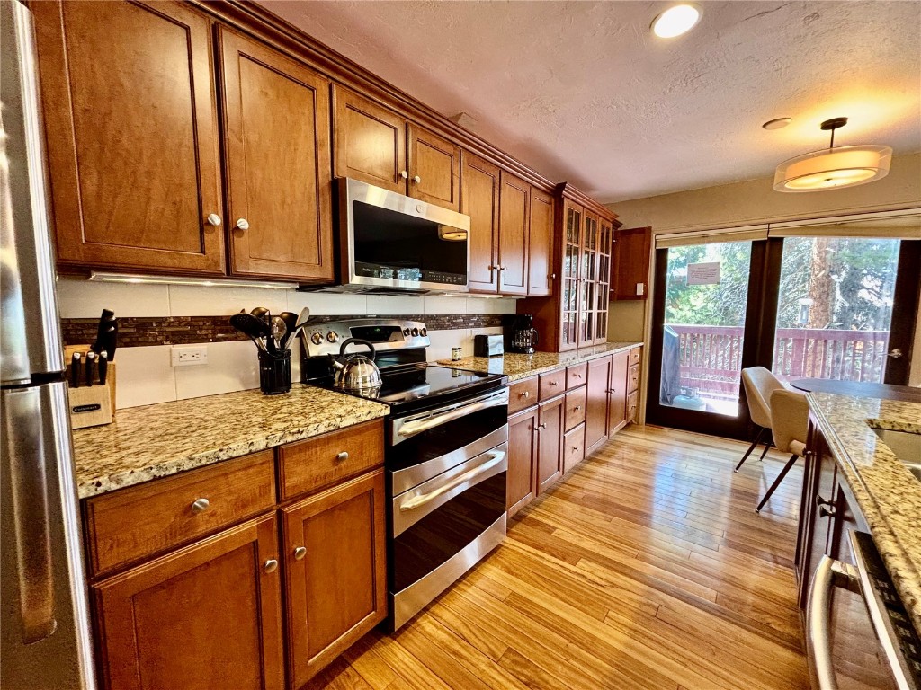 1310 Baldy Road, Unit D Breckenridge, CO 80424 - Photo 6 of 28 a kitchen with stainless steel appliances granite countertop wooden cabinets a stove top oven a sink and dishwasher