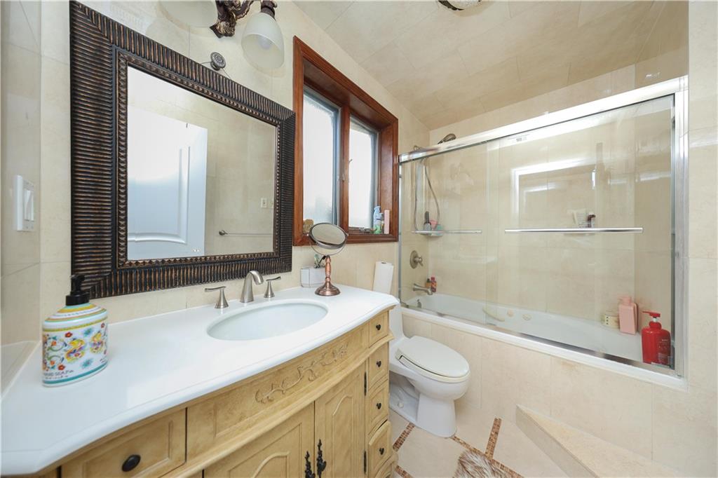 2568 East 2nd Street Brooklyn, NY 11223 - Photo 18 of 41 a bathroom with a sink a toilet and shower