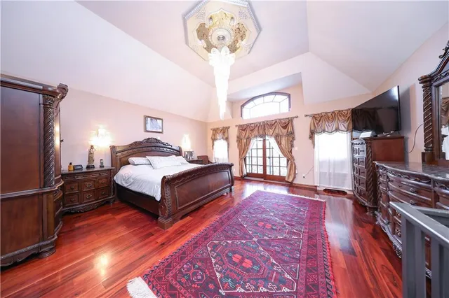 a spacious bedroom with a bed and a chandelier