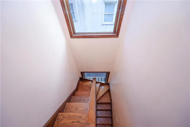 a spacious bedroom with a bed and wooden floor