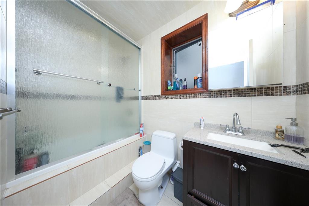 2568 East 2nd Street Brooklyn, NY 11223 - Photo 33 of 41 a bathroom with a sink a toilet and shower