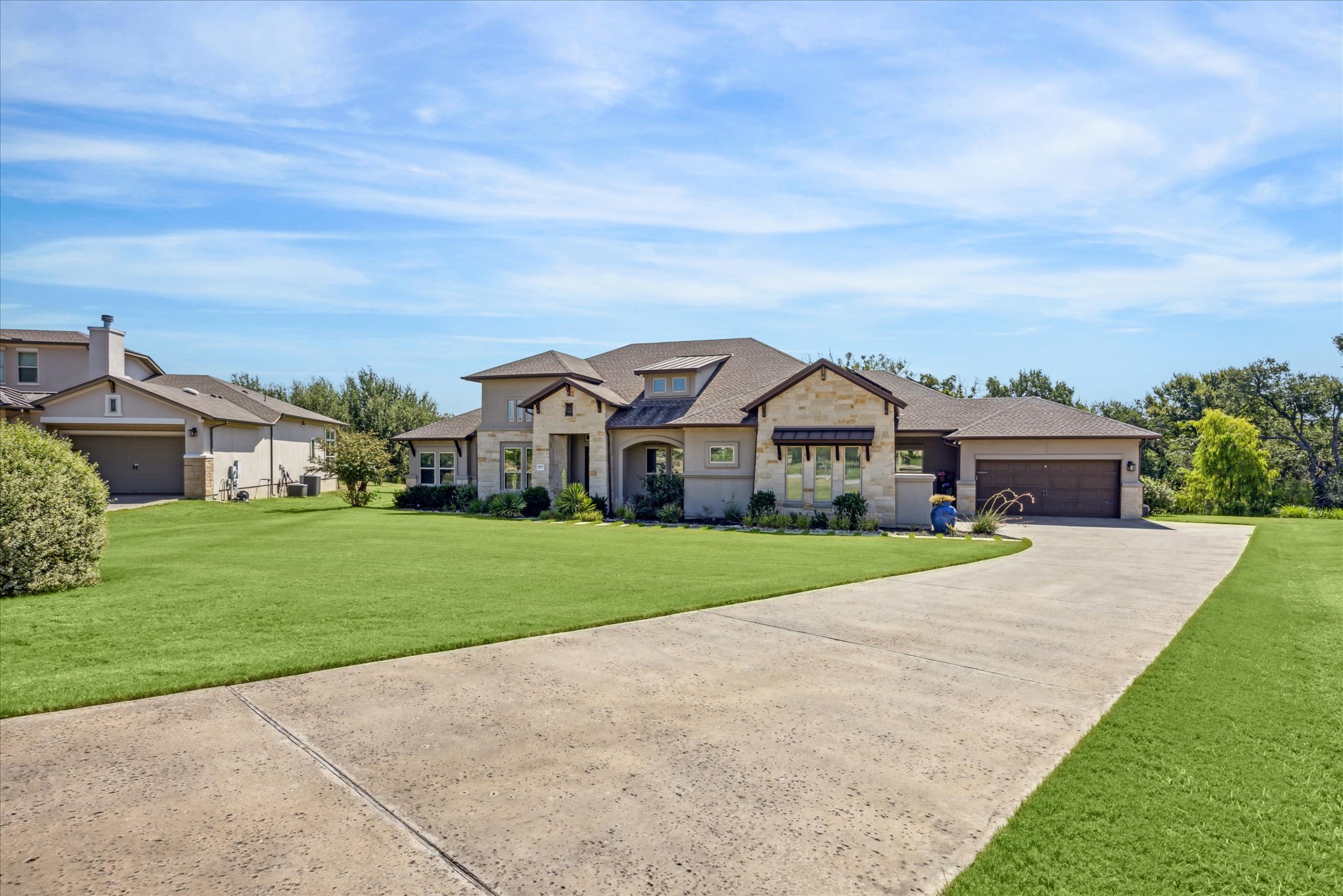 French country style house with a front yard, concrete driveway, and an attached garage