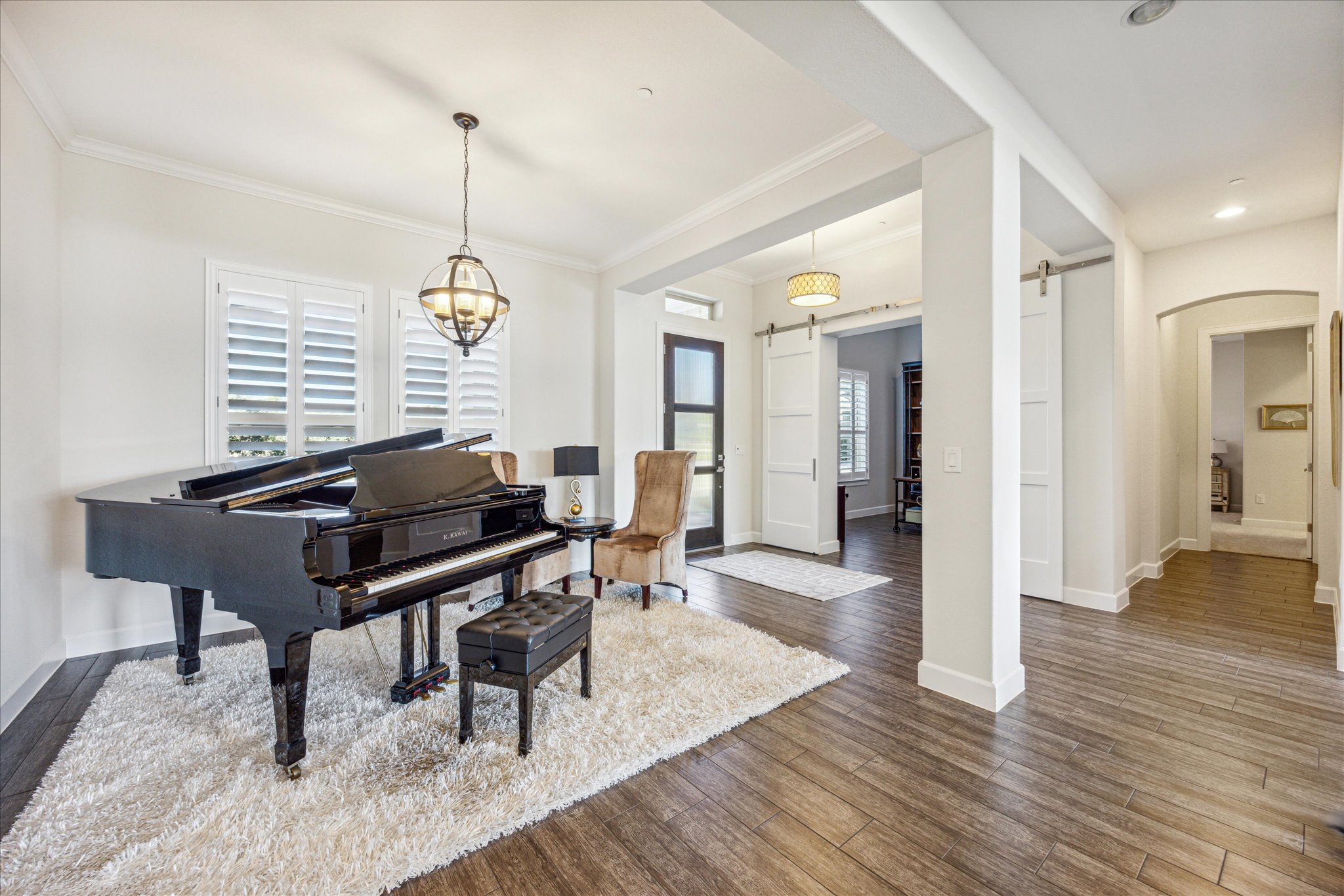 9600 Chamois Way Austin, TX 78736 - Photo 6 of 14 Living area with a barn door, dark wood-style floors, crown molding, and arched walkways