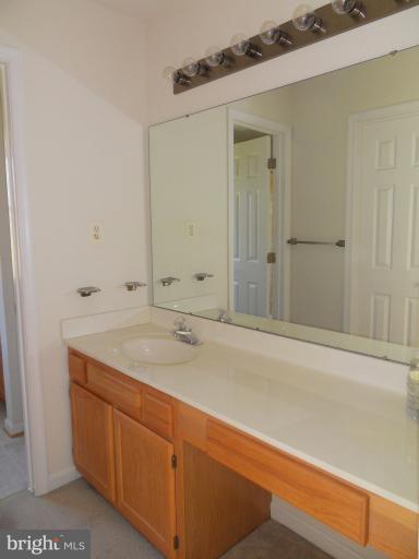 11026 George Street Lusby, MD 20657 - Photo 9 of 20 a bathroom with a granite countertop sink and mirror