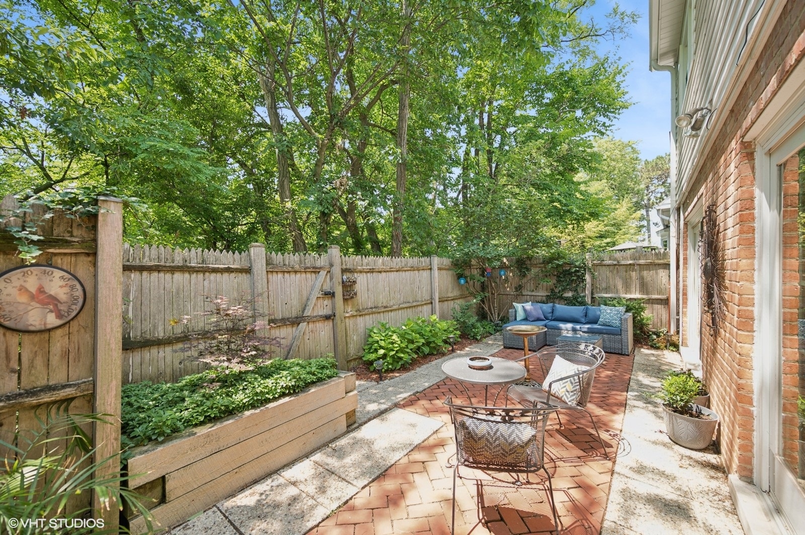 730 Oak Street Winnetka, IL 60093 - Photo 22 of 28 a view of a patio with table and chairs with wooden fence and plants