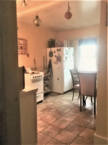 a kitchen with a stove a refrigerator and a table