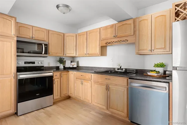 a kitchen with granite countertop white cabinets white stainless steel appliances and a sink