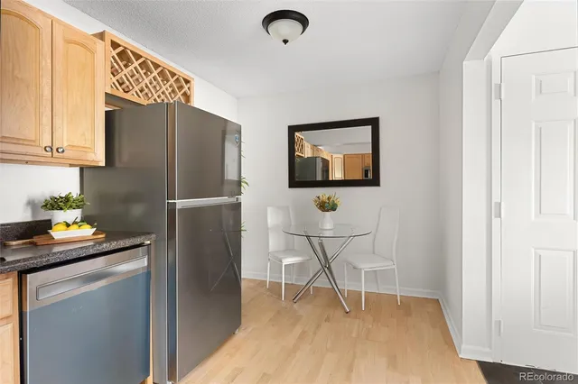a kitchen with a refrigerator and a wooden floor