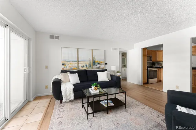 a living room with furniture and a dining table with kitchen view
