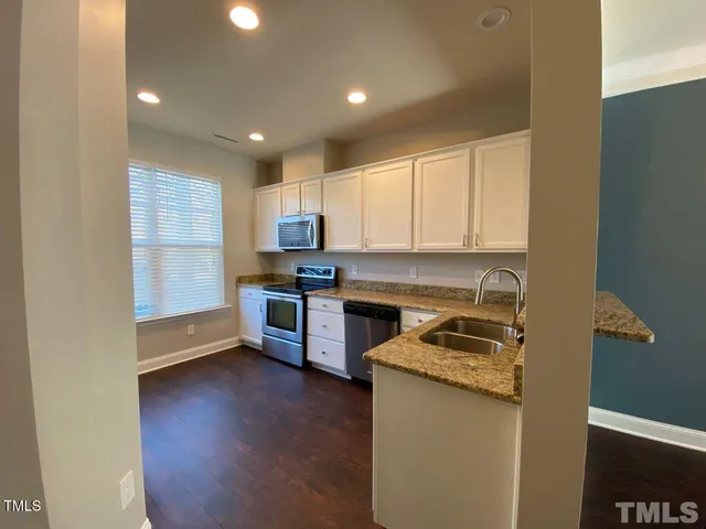 a kitchen with stainless steel appliances granite countertop a stove a sink and a refrigerator