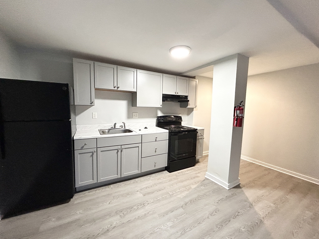a kitchen with a refrigerator and a stove top oven