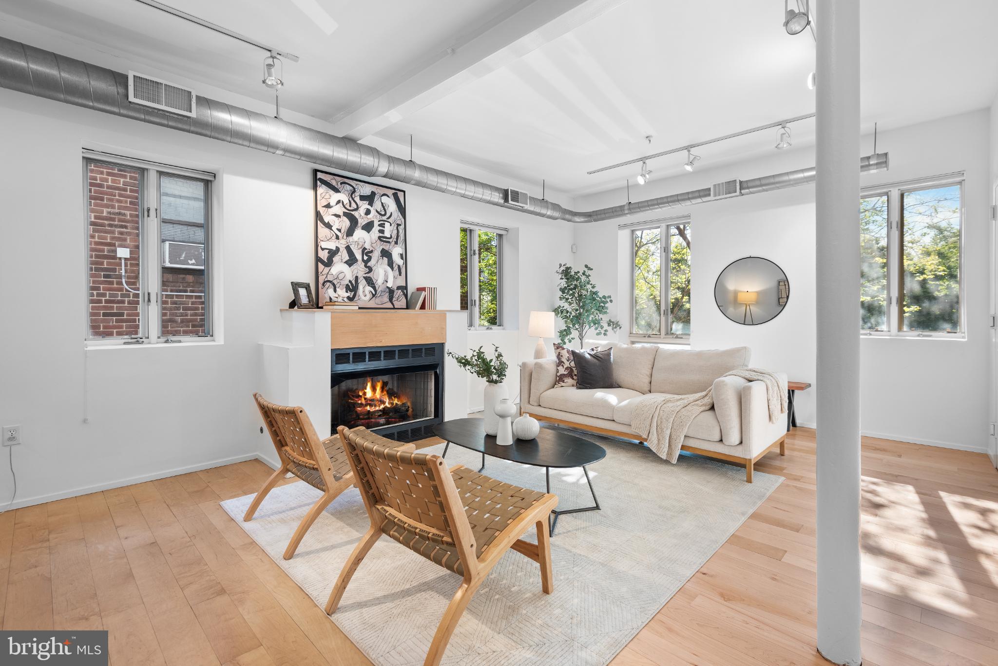 a living room with fireplace furniture and a large window