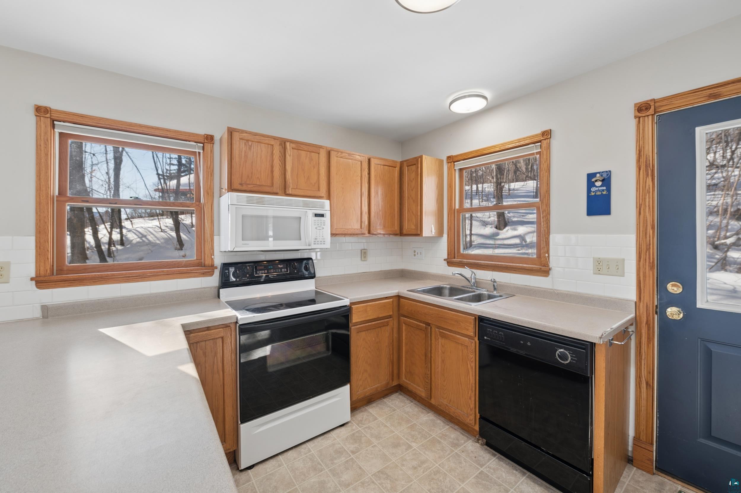 33 South 4th Street Bayfield, WI 54814 - Photo 14 of 29 Kitchen with range with electric cooktop, dishwasher, white microwave, light countertops, and tasteful backsplash