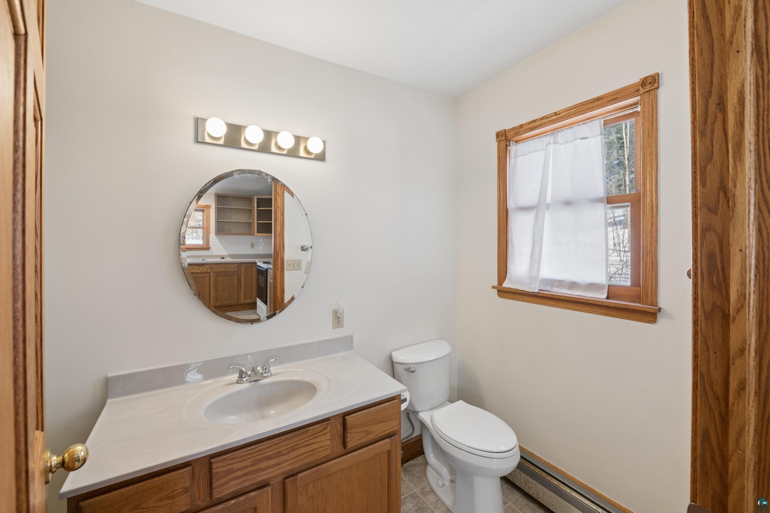 33 South 4th Street Bayfield, WI 54814 - Photo 25 of 29 Bathroom with vanity, light tile patterned flooring, and baseboard heating