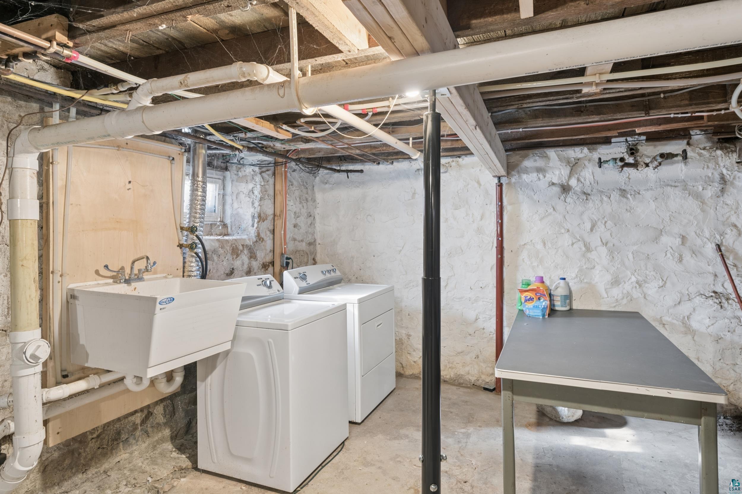 33 South 4th Street Bayfield, WI 54814 - Photo 27 of 29 Laundry area with unfinished concrete floors and washing machine and clothes dryer