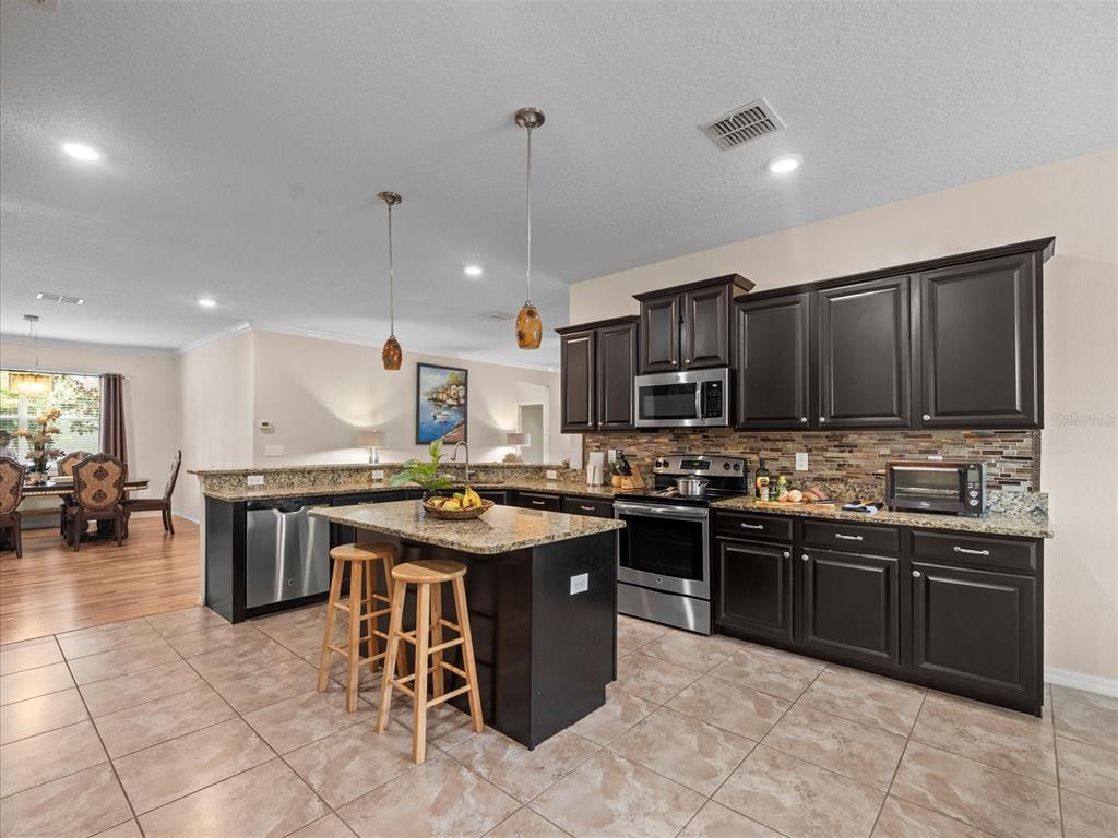 12722 Drakefield Drive Spring Hill, FL 34610 - Photo 15 of 45 a kitchen with lots of counter top space appliances and cabinets