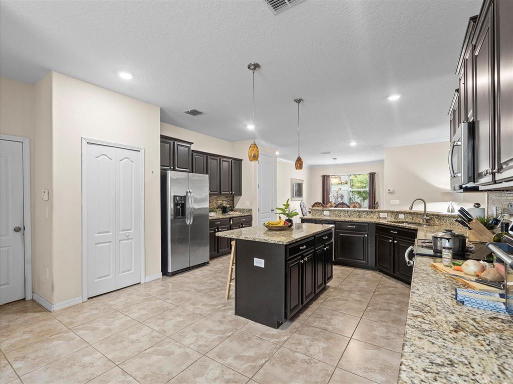 12722 Drakefield Drive Spring Hill, FL 34610 - Photo 17 of 45 a kitchen with stainless steel appliances granite countertop a stove refrigerator sink and cabinets