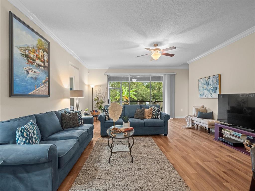 12722 Drakefield Drive Spring Hill, FL 34610 - Photo 19 of 45 a living room with furniture a flat screen tv and a large window
