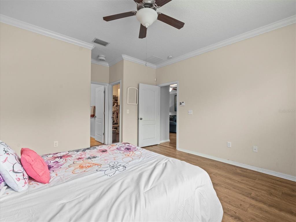 12722 Drakefield Drive Spring Hill, FL 34610 - Photo 27 of 45 a bedroom with a bed and a chandelier