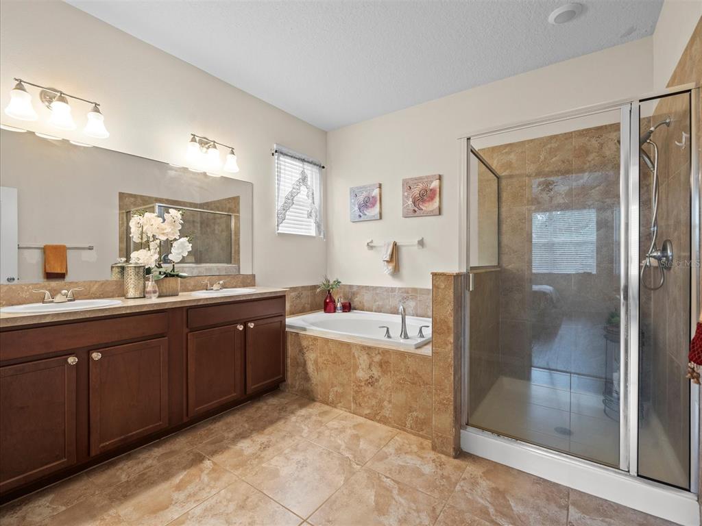 12722 Drakefield Drive Spring Hill, FL 34610 - Photo 30 of 45 a spacious bathroom with a tub sink and mirror