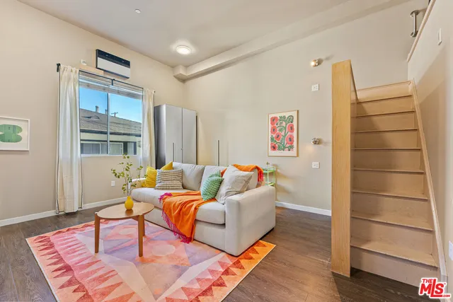 a living room with furniture rug and wooden floor
