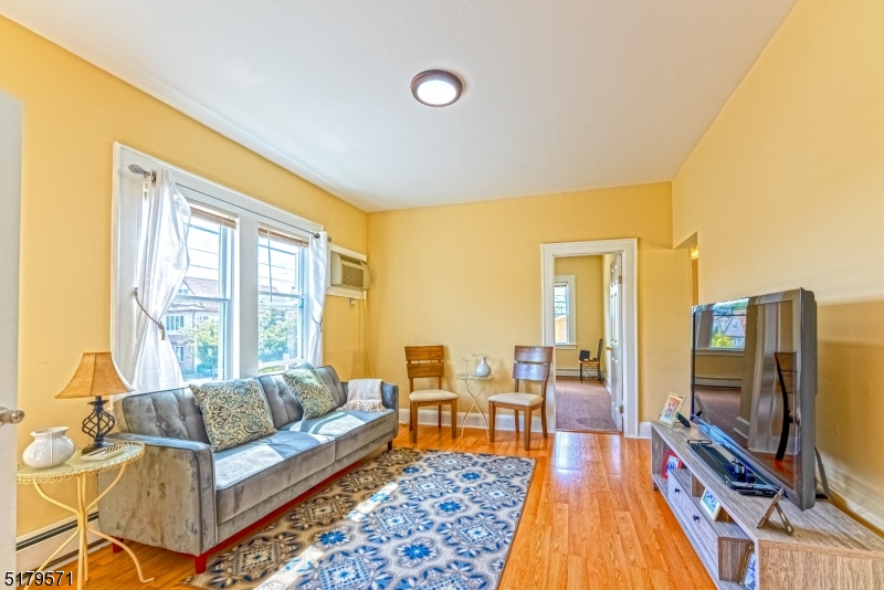 146 Main Street, Unit 2 Garfield, NJ 07026 - Photo 3 of 14 a living room with furniture a flat screen tv and a table