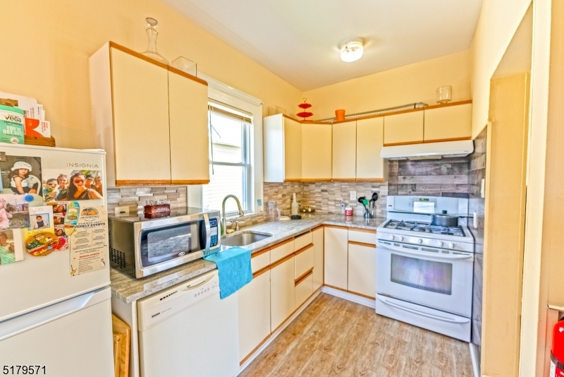 146 Main Street, Unit 2 Garfield, NJ 07026 - Photo 5 of 14 a kitchen with stainless steel appliances a stove and white cabinets