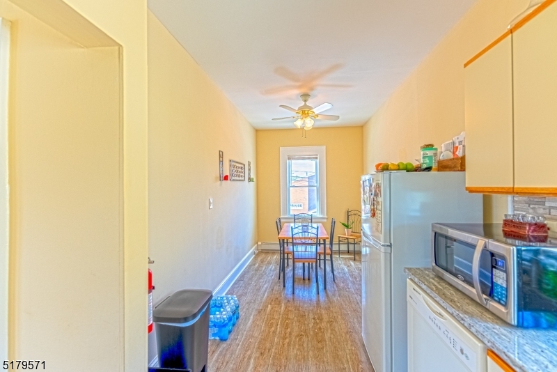 146 Main Street, Unit 2 Garfield, NJ 07026 - Photo 6 of 14 a view of a dining room with furniture a chandelier and wooden floor