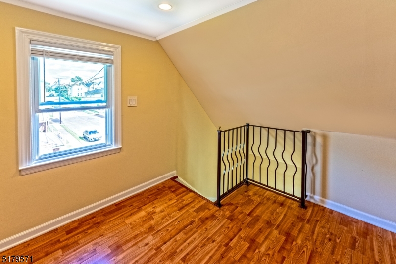 146 Main Street, Unit 2 Garfield, NJ 07026 - Photo 7 of 14 a view of an empty room with wooden floor and a window