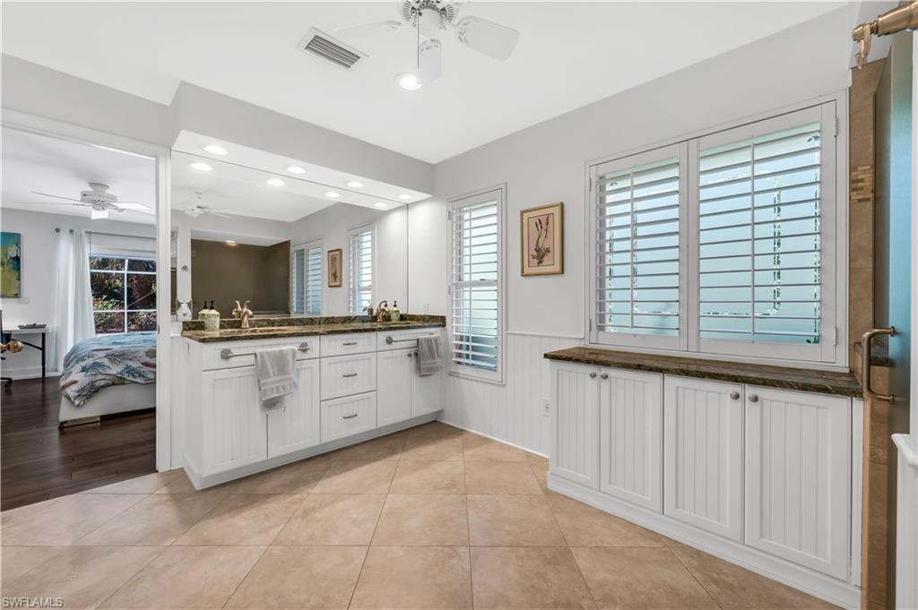 183 Edgemere Way South Naples, FL 34105 - Photo 13 of 42 Bathroom with ensuite bath, double vanity, a ceiling fan, wainscoting, and recessed lighting