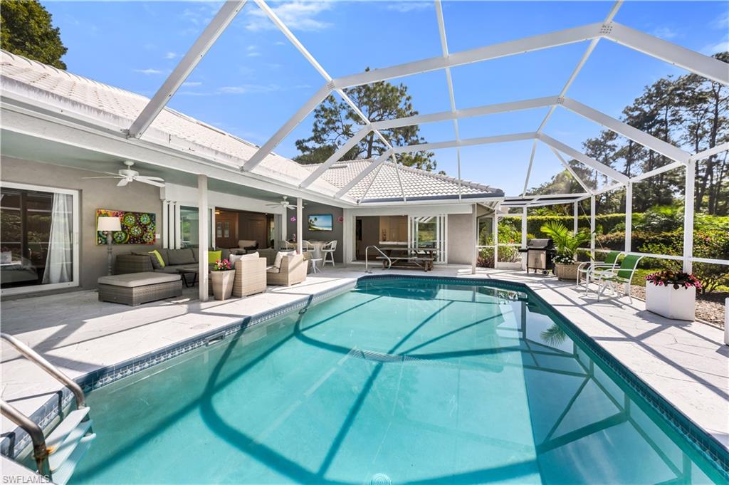 183 Edgemere Way South Naples, FL 34105 - Photo 19 of 42 Swimming pool with outdoor lounge area, a patio, a sunroom, and glass enclosure