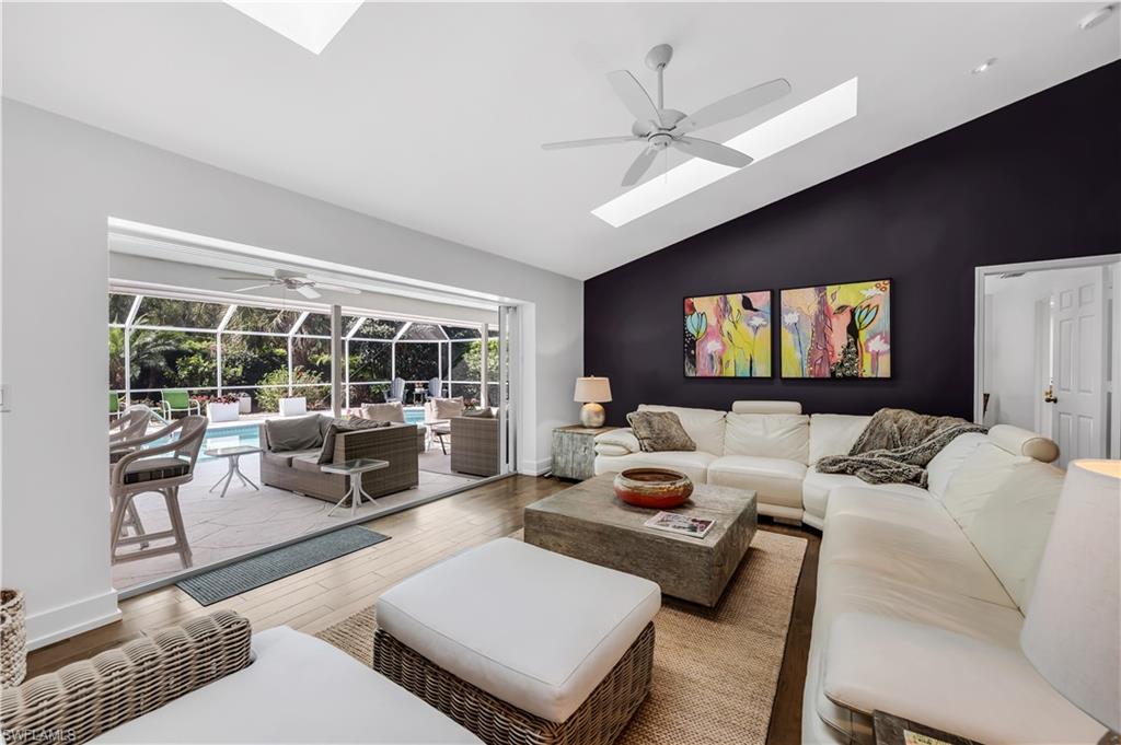 183 Edgemere Way South Naples, FL 34105 - Photo 5 of 42 Great room with a sunroom, ceiling fan, wood finished floors, and lofted ceiling
