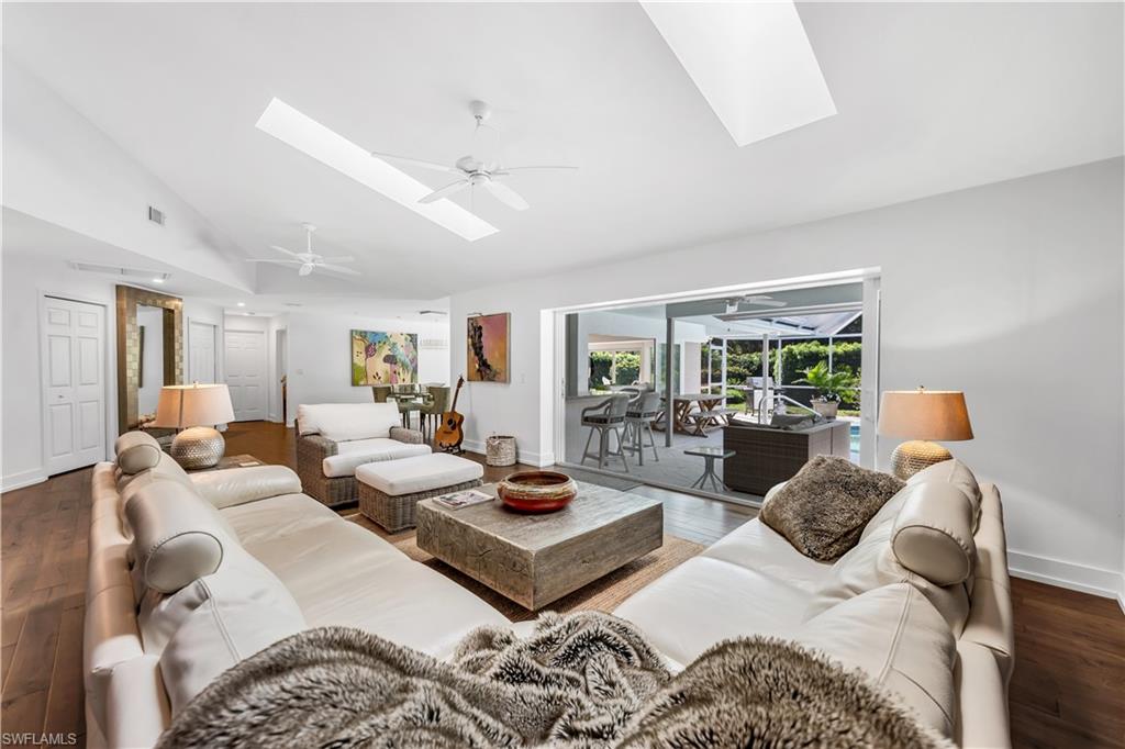 183 Edgemere Way South Naples, FL 34105 - Photo 6 of 42 Great room featuring a ceiling fan, hardwood / wood-style flooring, a skylight, a sunroom, and lofted ceiling