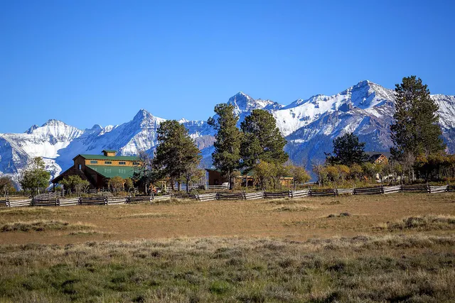 a living room with furniture a fireplace and floor to ceiling windows