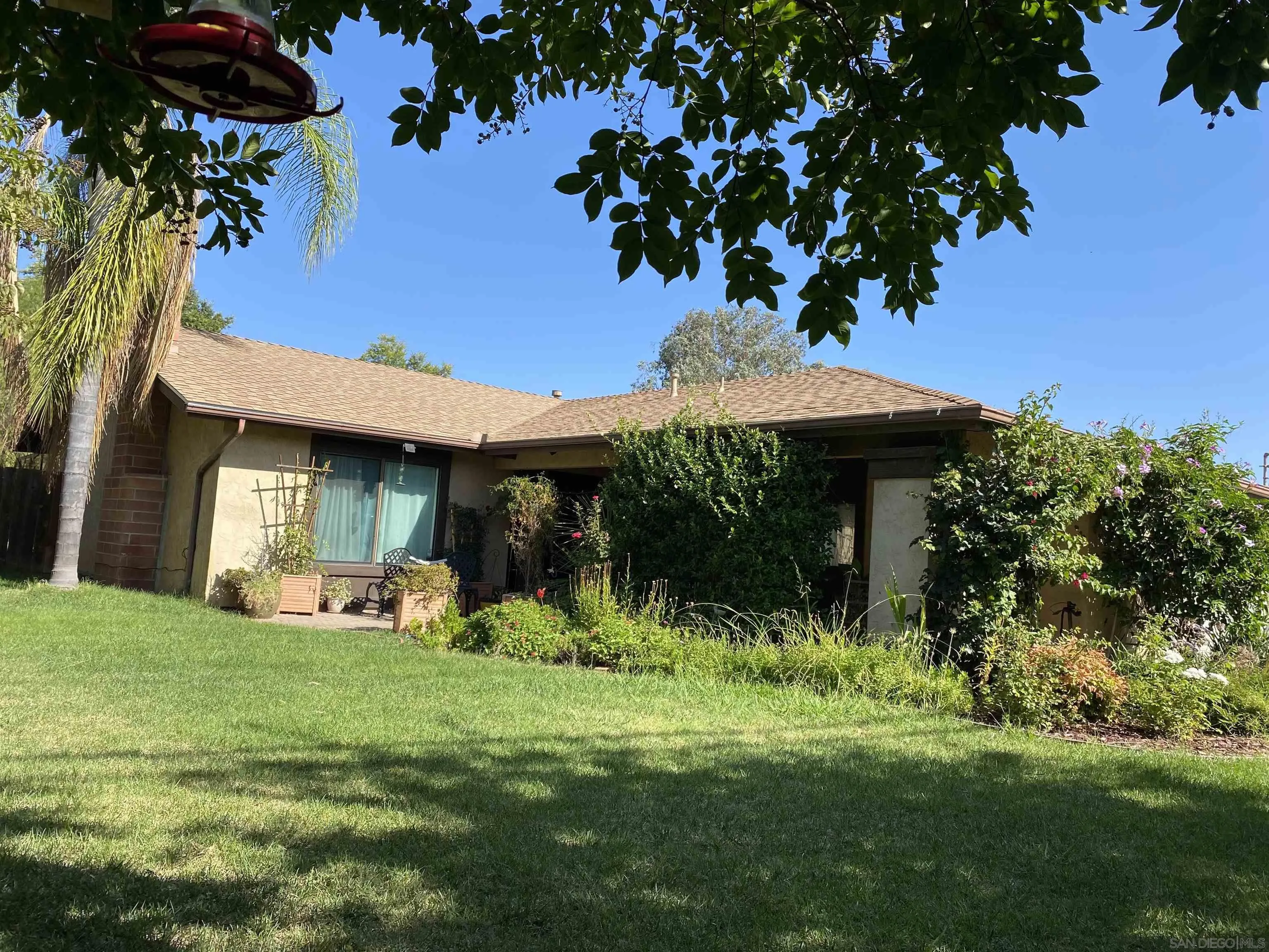 a view of a house with a yard potted plants and a fountain