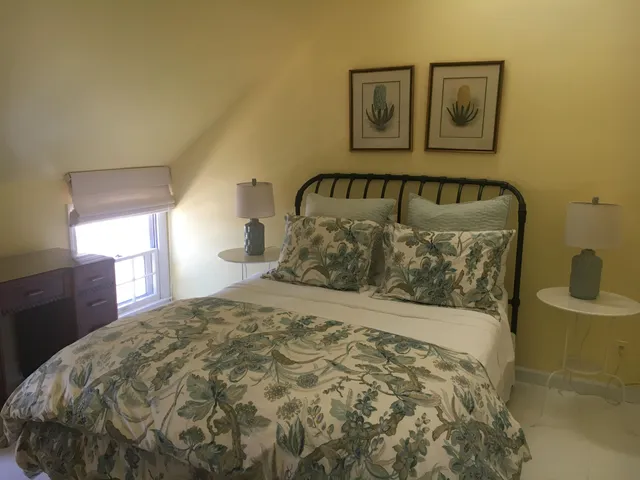 a large bed sitting in a bedroom next to a window